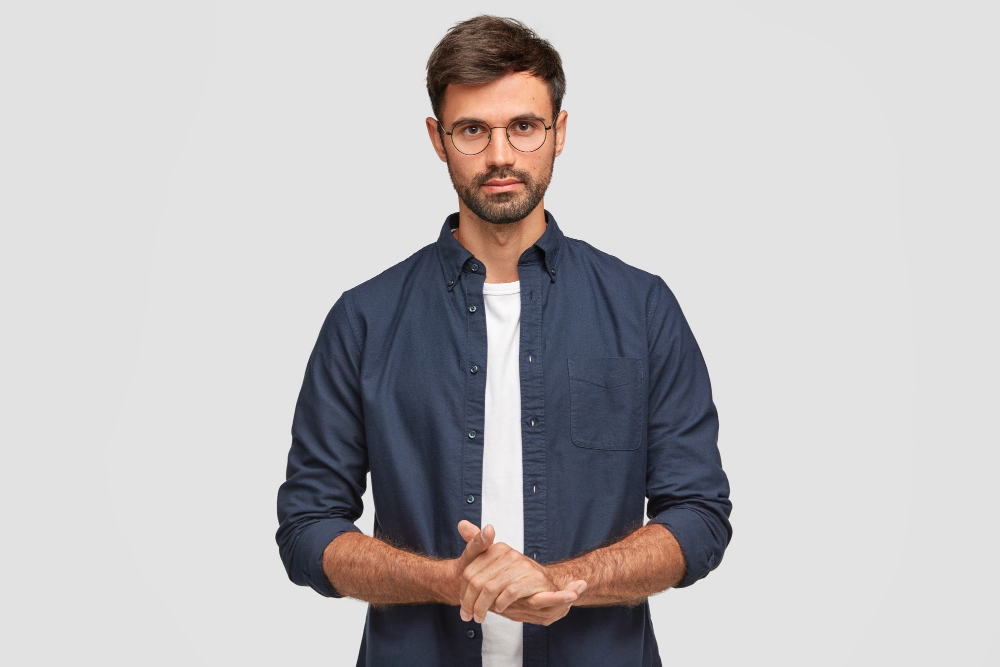 //yaazhistudio.in/wp-content/uploads/2022/08/waist-up-portrait-handsome-serious-unshaven-male-keeps-hands-together-dressed-dark-blue-shirt-has-talk-with-interlocutor-stands-against-white-wall-self-confident-man-freelancer.jpg